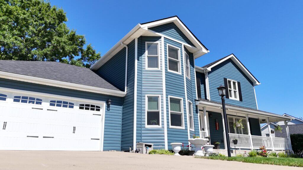 Two-story home with blue vinyl siding and white gutters in Lexington, KY